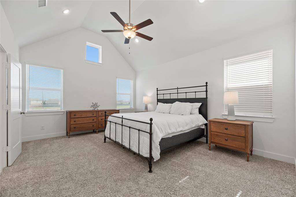 The large primary bedroom is conveniently located upstairs and features a high ceiling, ceiling fan, plush carpet and an en-suite bathroom.