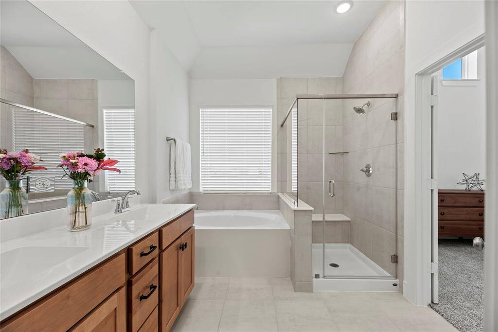 The primary bathroom is complete with a dual sink vanity, soaking tub, separate shower and walk-in closet.