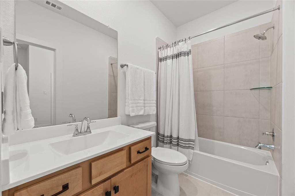 Secondary bathroom with a large vanity and a tub/shower combination.