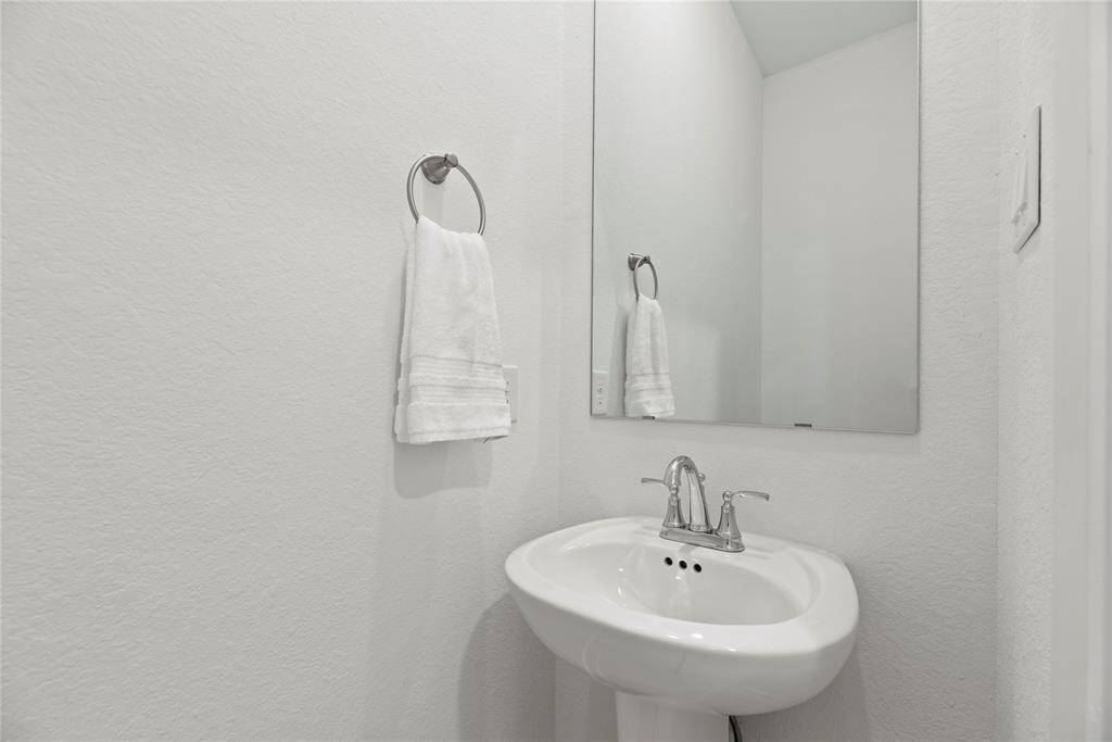 Downstairs half bathroom boasts a pedestal sink.