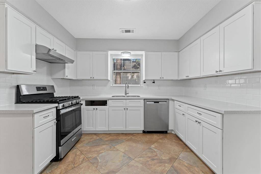 The window over the sink brings in plenty of natural light, creating a bright and airy feel. (missing drawer will be replaced.)