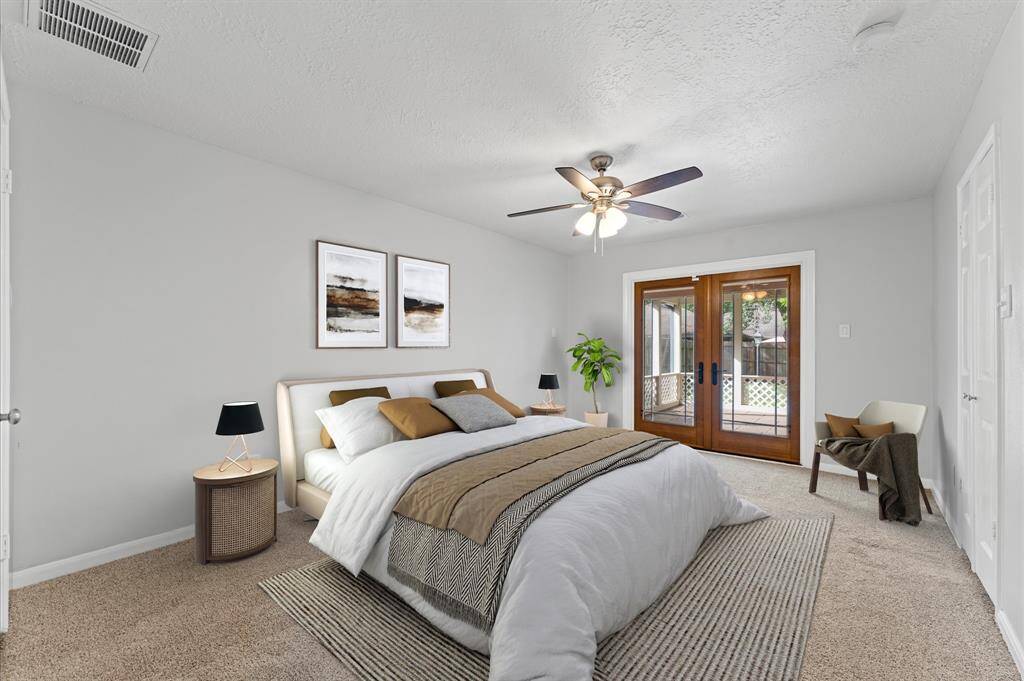 Virtually Staged---Primary bedroom offers a serene retreat, featuring French doors that open directly to the screened-in patio.