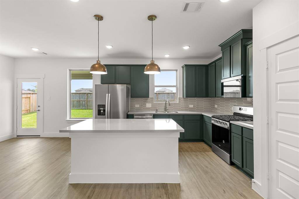 Every detail has been thoughtfully designed, from the state-of-the-art appliances that make meal prep a breeze, to the charming backsplash that adds a touch of personality.