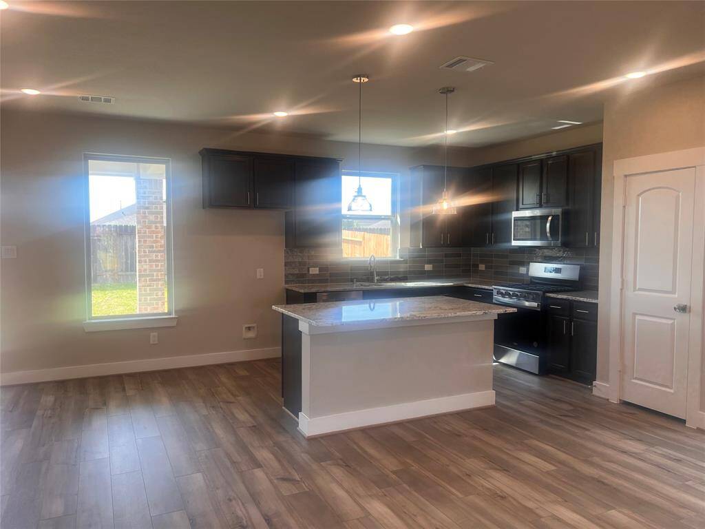 Natural light pours in through large windows, creating a bright and airy atmosphere that makes cooking feel less like a chore and more like a delightful experience.