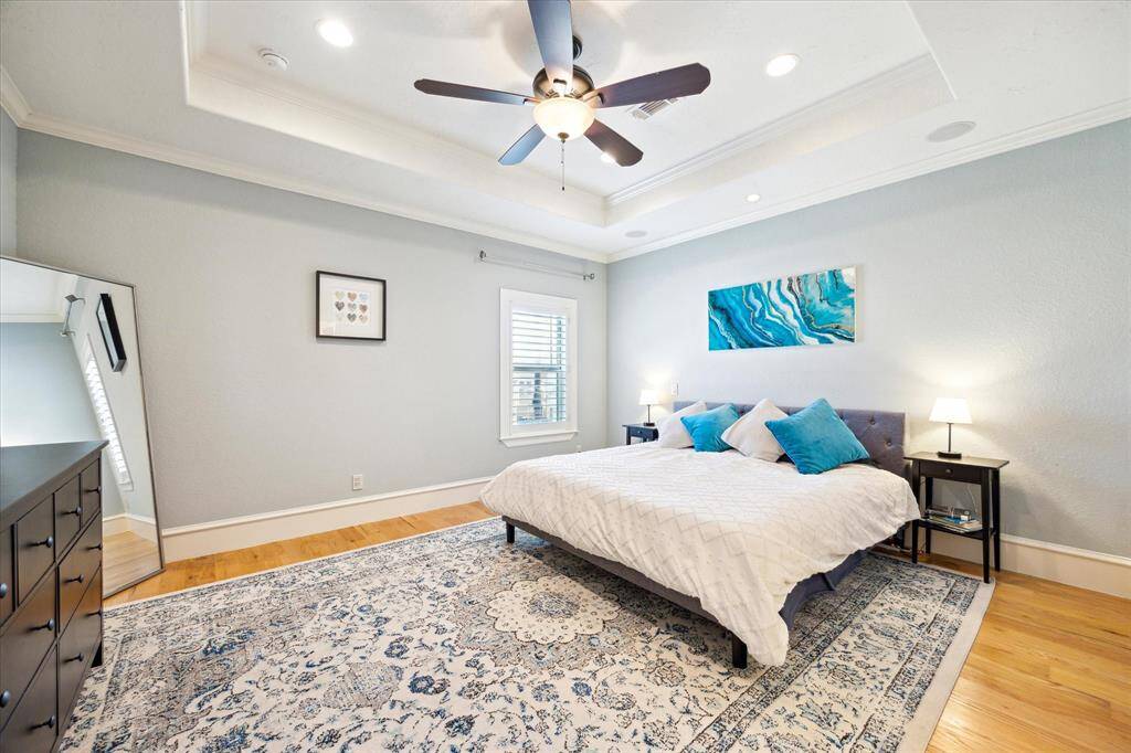 [Primary Bedroom] The main primary bedroom, one of two located on the second floor, is filled with natural light and features elegant tray ceilings.