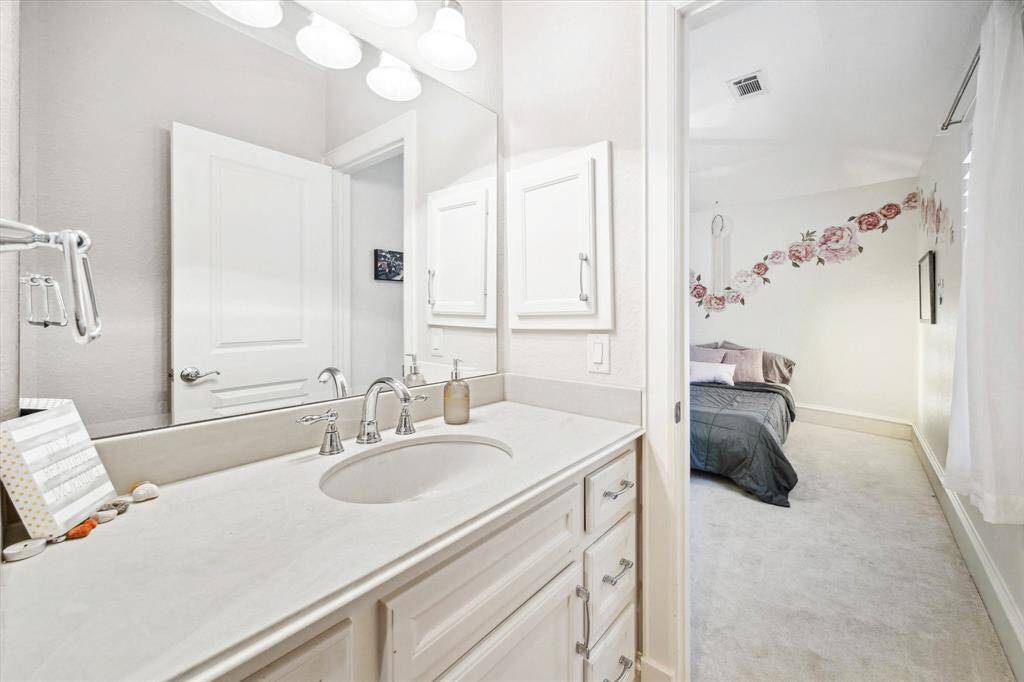 The bathroom offers plenty of counter space, bright cabinetry, and a convenient tub/shower combo.