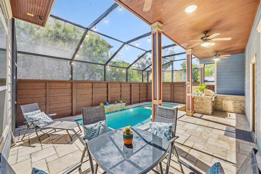 The spacious pool area is perfect for entertaining and soaking up the sun. Covered to keep bugs away, it features a saltwater pool with a beautiful water feature.