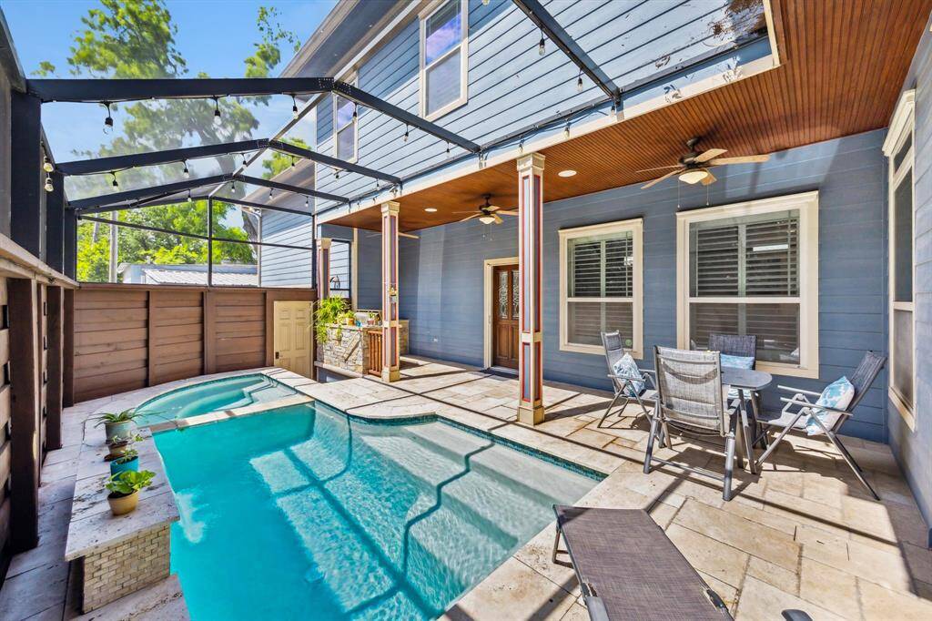 The perfectly sized saltwater pool is ideal for relaxation and enjoyment. Also pictured is the side door, providing private access to your driveway and alleyway—perfect for guest entry.