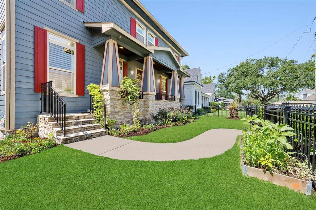 Enter through the front gate to lush landscaping and a charming walkway leading to the front porch.