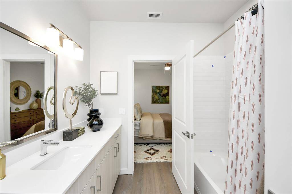 Full secondary bathroom with tub/shower combo and vanity area.