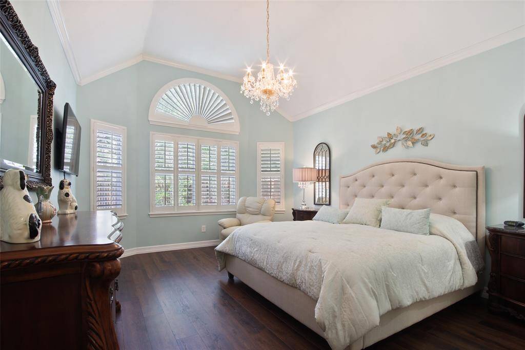 Stunning Coastal Look Primary Bedroom with Plantation Shutters and wood floors on the first floor.