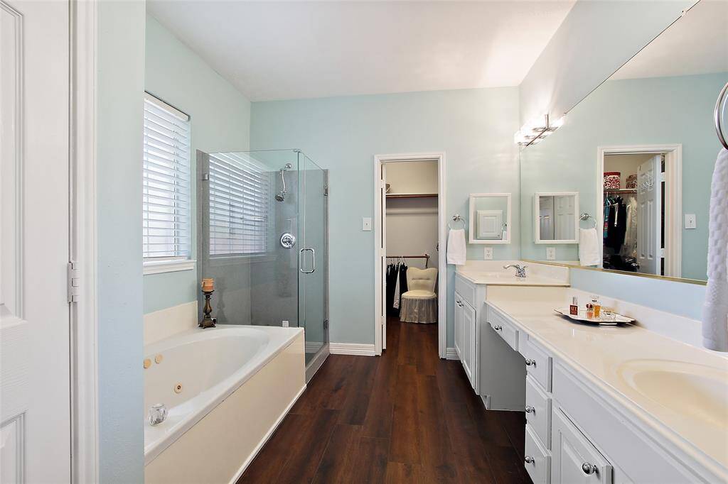 Primary Bathroom en suite separate shower and tub with large closet and wood floors.