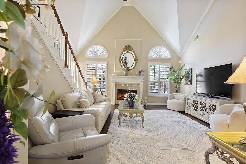 Tall ceilings in Family Room with Plantation Shutters and wood floors.