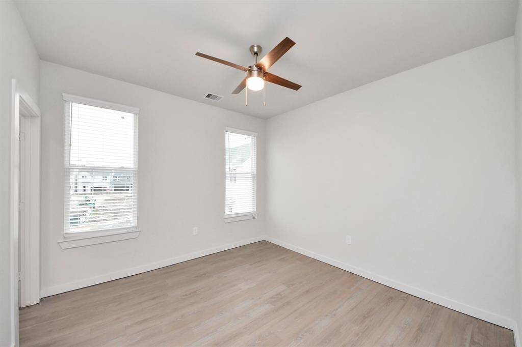 Secondary Bedroom with wood-like floors, closet and ensuite full bath with tub/shower combo.