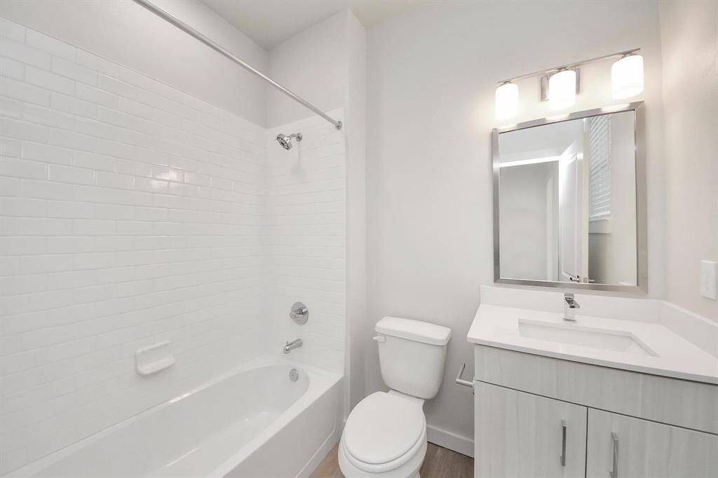 Full secondary bathroom with tub/shower combo and vanity area.