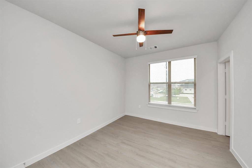Secondary Bedroom with wood-like floors and closet in additional to an ensuite full bathroom.