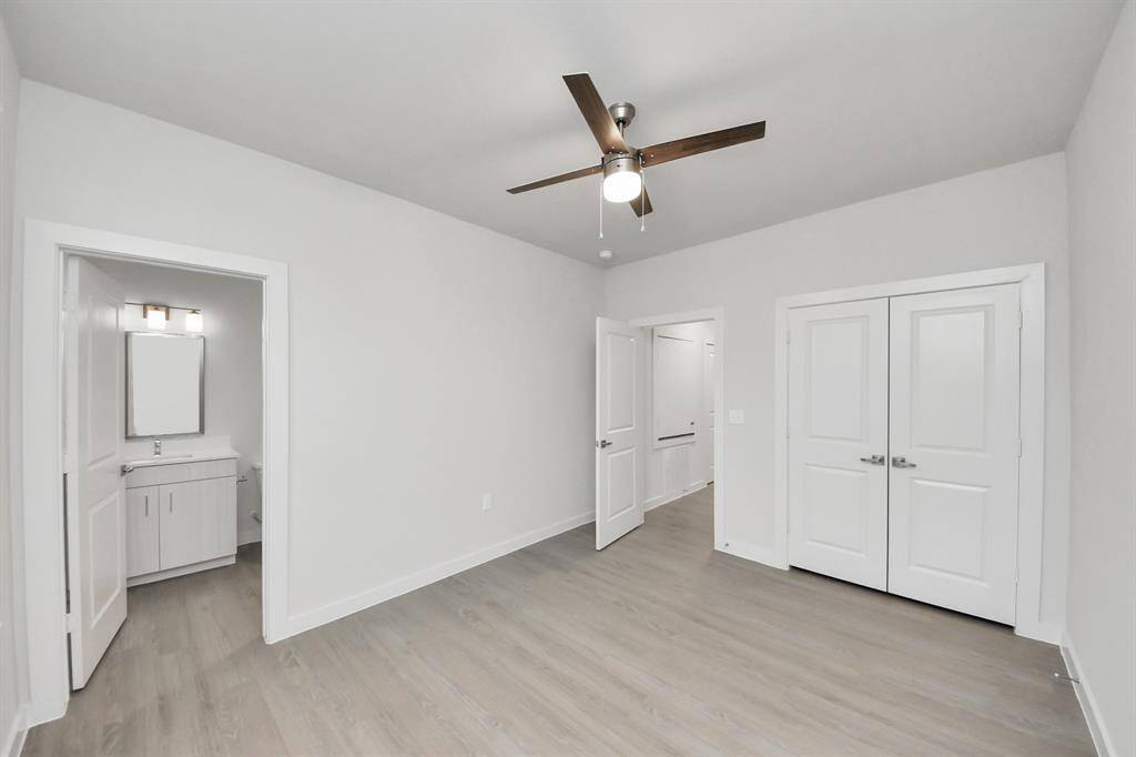Secondary Bedroom with wood-like floors and closet in additional to an ensuite full bathroom.
