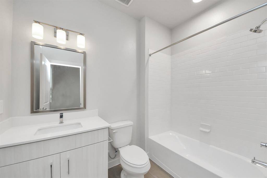 Full secondary ensuite bathroom with tub/shower combo and vanity area.