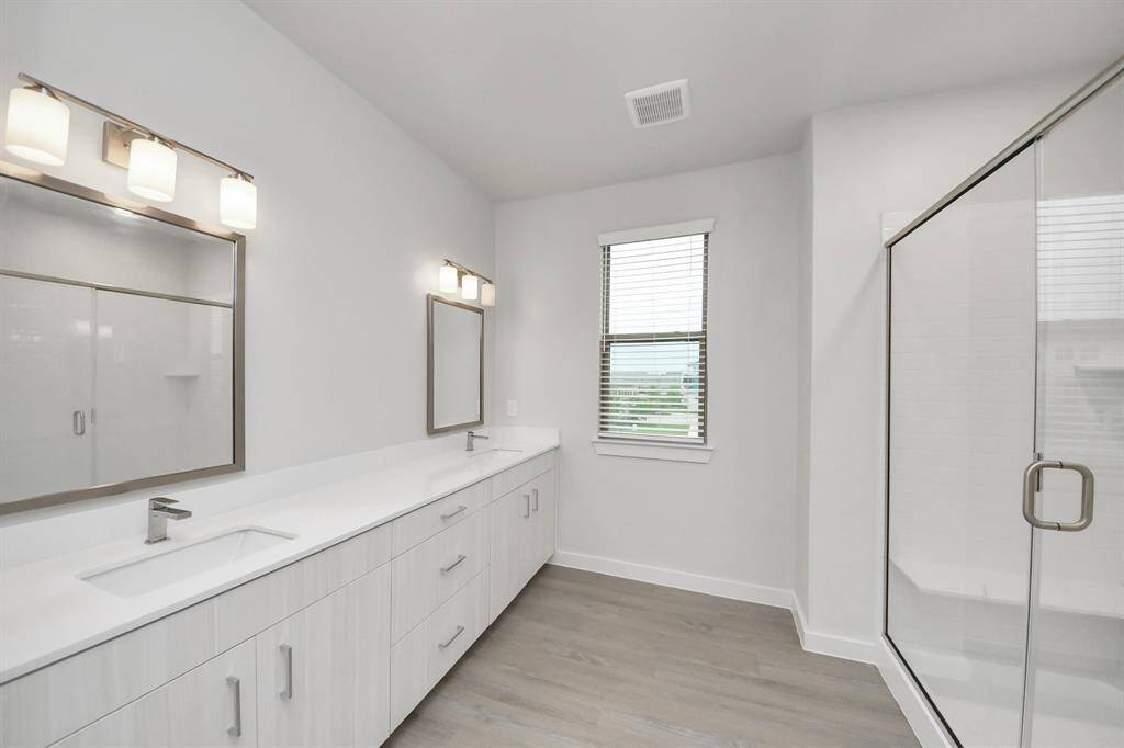 Spacious Owner’s retreat with wood-like floors, walk-in closet and spa-like bath w/dual sinks.