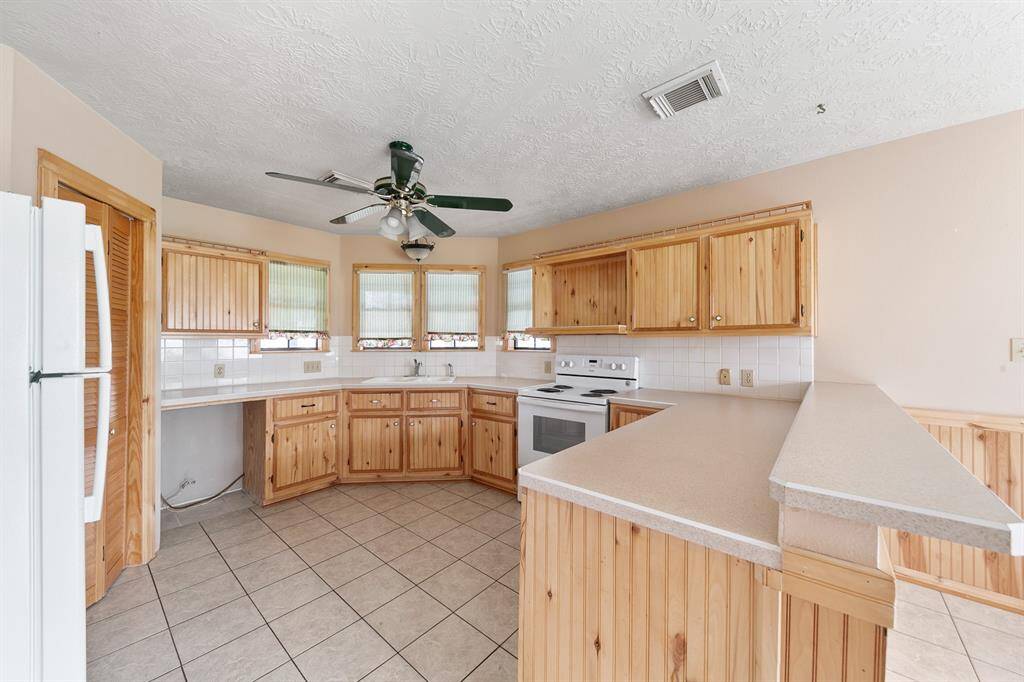 The kitchen is equipped with durable tile floors, offering easy maintenance and a sleek, functional look that complements the space.