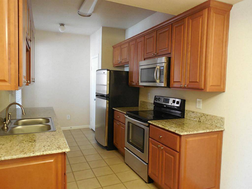 Tiled kitchen with plenty of cabinets and granite countertops