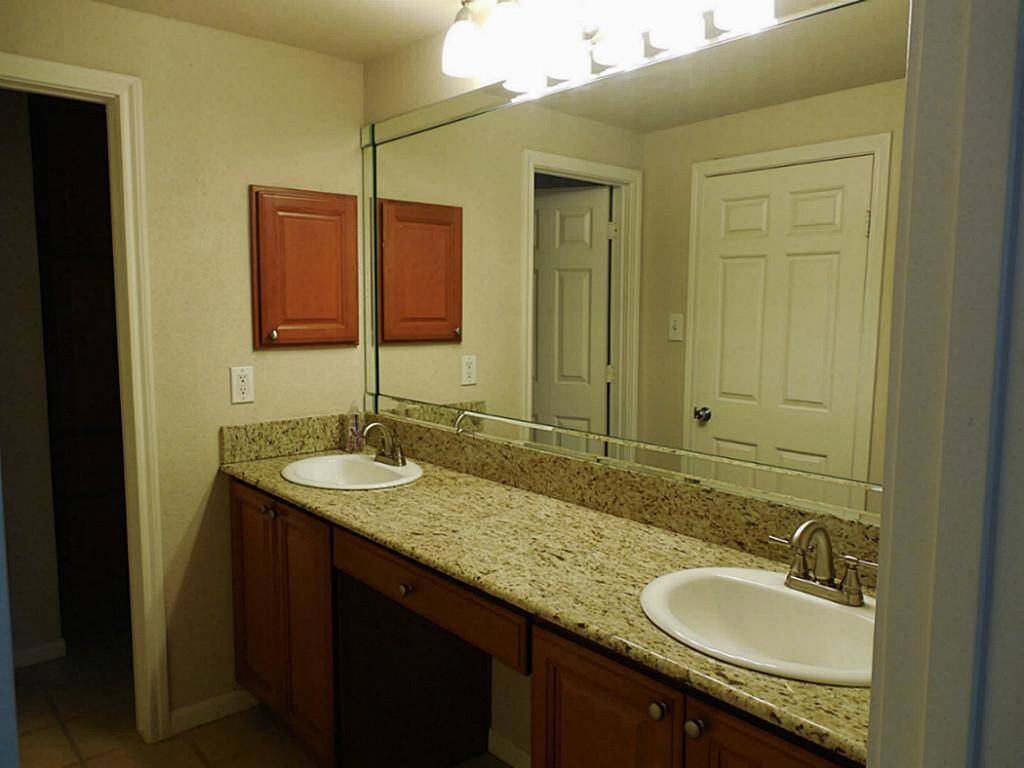 Double sinks and granite counters in the bathroom.  Bathroom is also accessible from the dining area