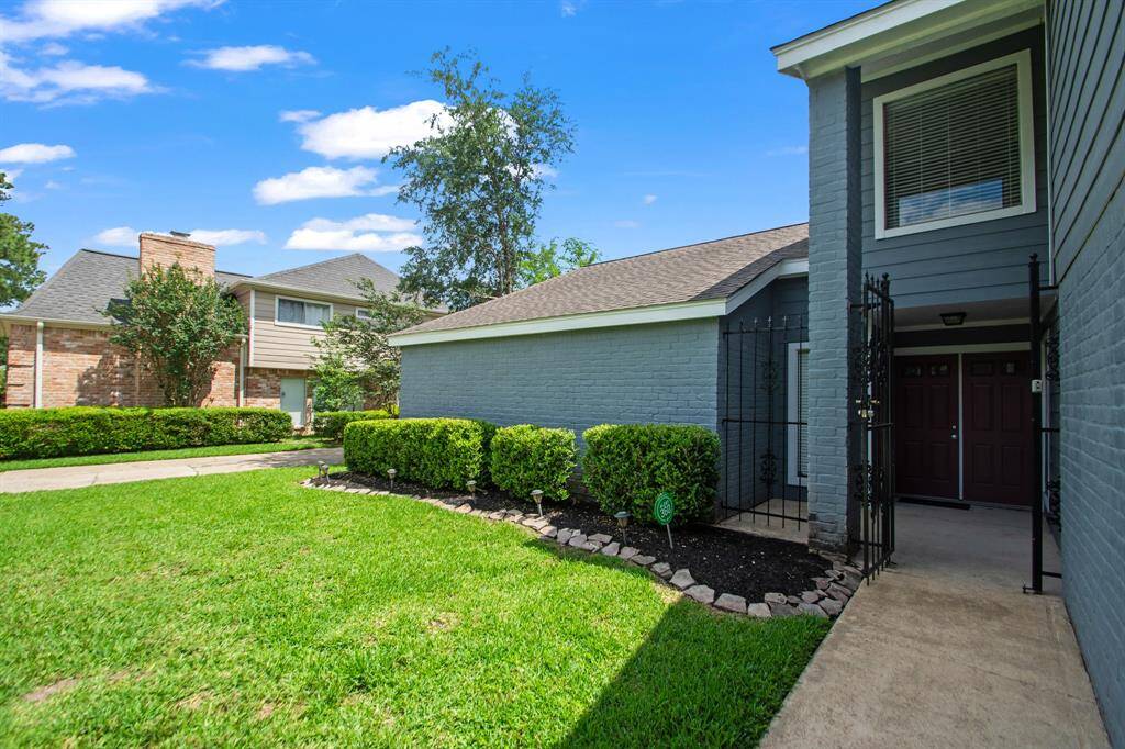 A charming black iron gate welcomes you to the home, leading to a cozy front porch—an inviting entryway that adds both curb appeal and a touch of privacy.
