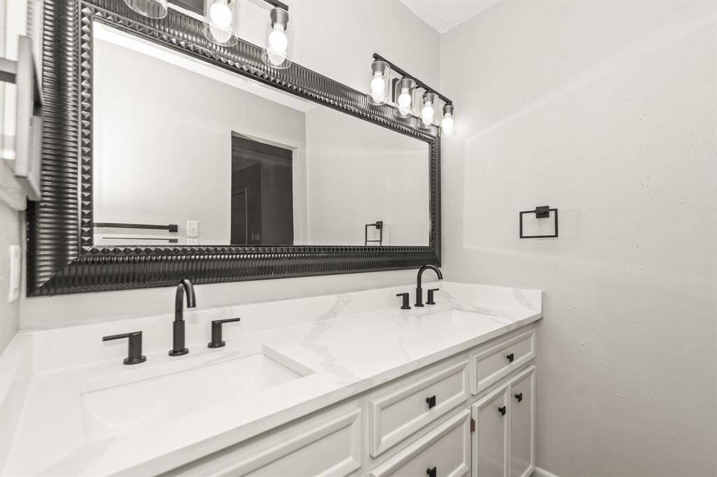 The primary bath features luxurious quartz countertops with double sinks, offering both style and functionality.