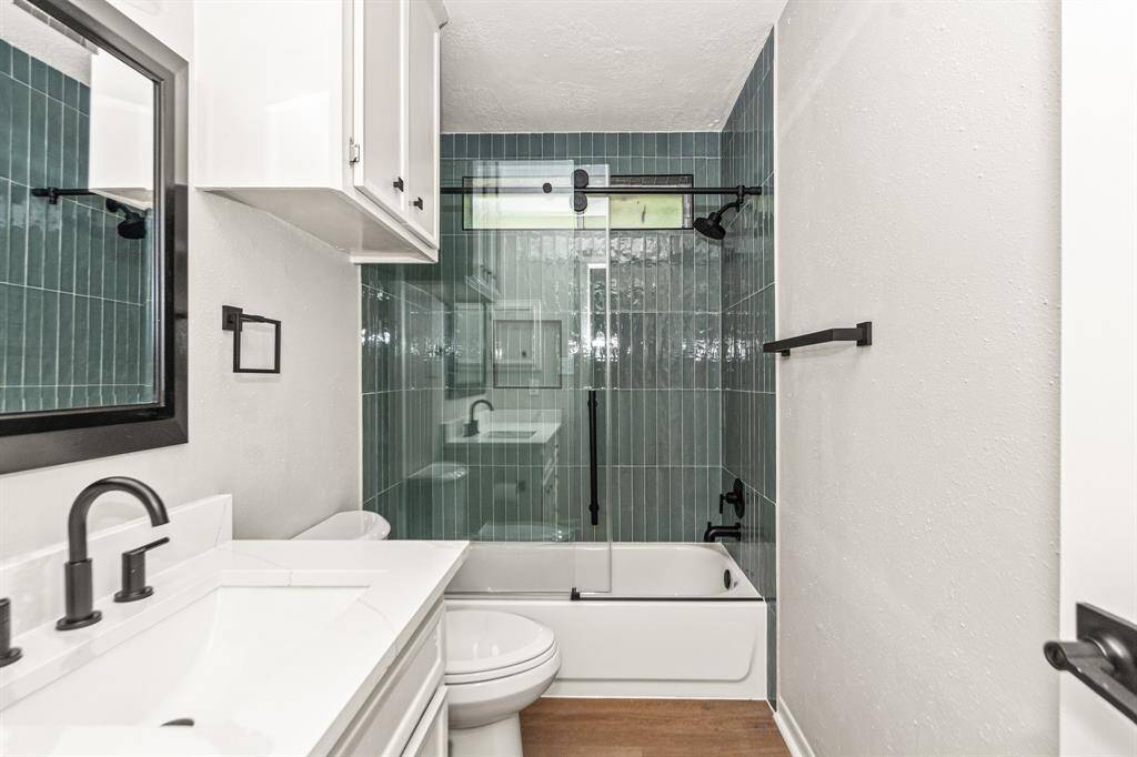 This secondary bath also features a new toilet, glass shower enclosure, counter tops, lighting, flooring, and hardware.