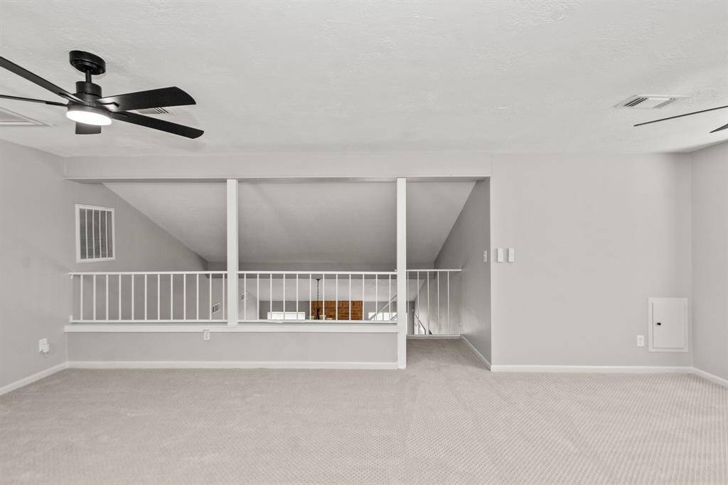 Upstairs flex space features brand-new carpet, fresh paint, new fans, and an open view overlooking the living area below—perfect for a home office, playroom, or media lounge.
