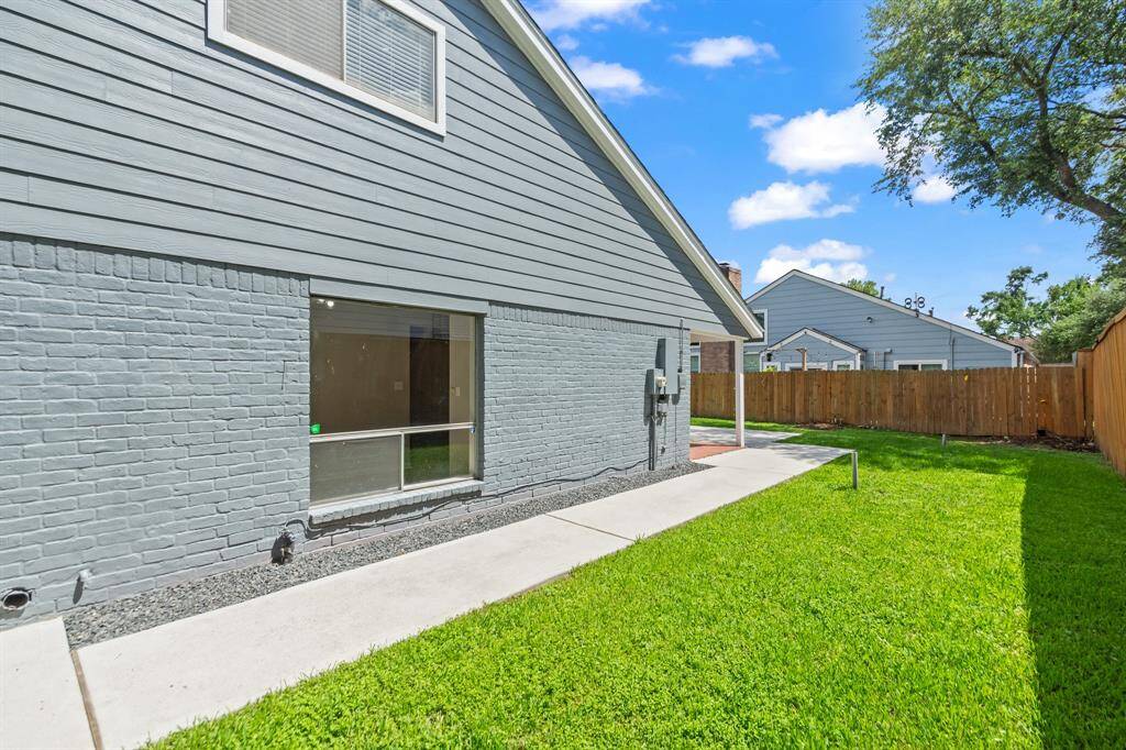 The side yard stretches an estimated 62 feet in length and features a wooden gate that provides convenient access to the front of the house.