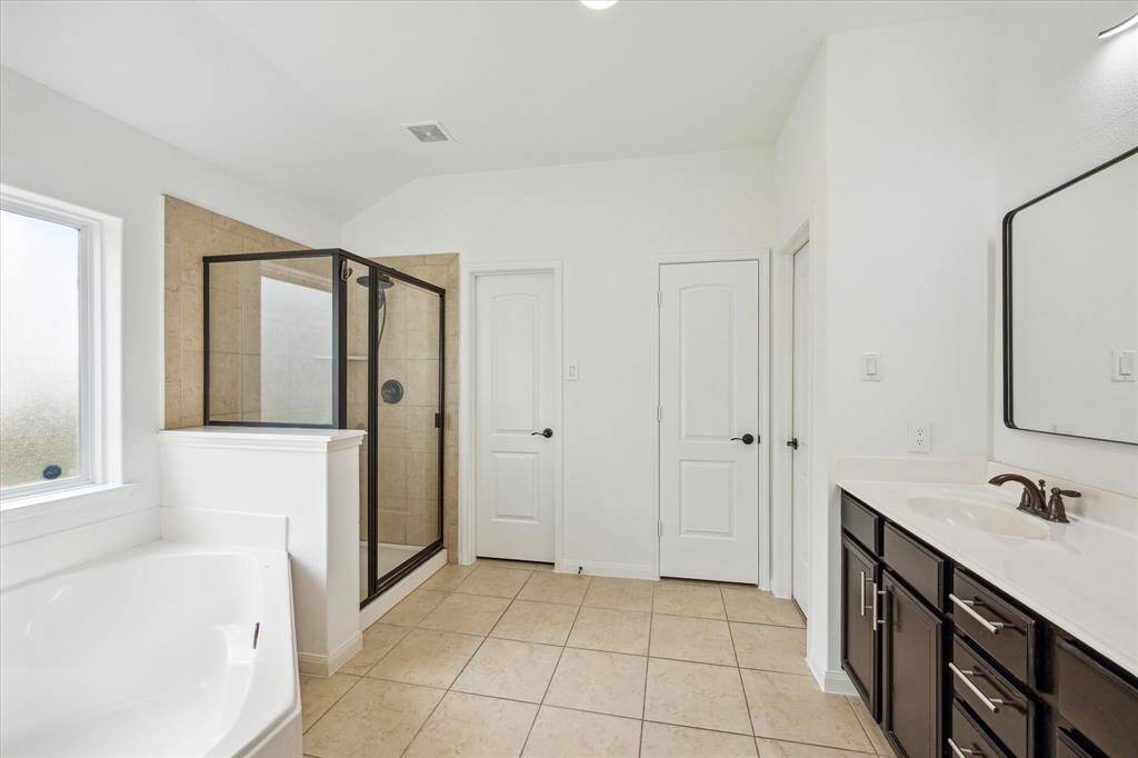 Another view of the primary bathroom with access to both closets and the private water closet.