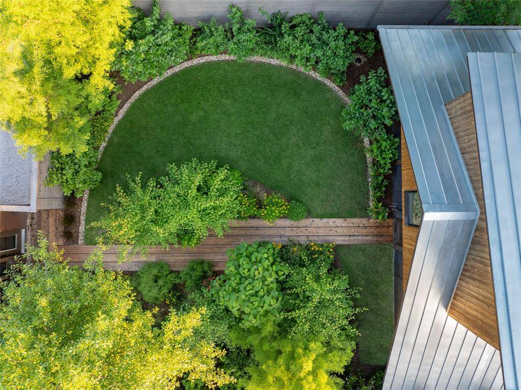 Discover serenity in this beautifully landscaped garden, a harmonious blend of lush greenery and modern design, offering a private oasis for relaxation and enjoyment.