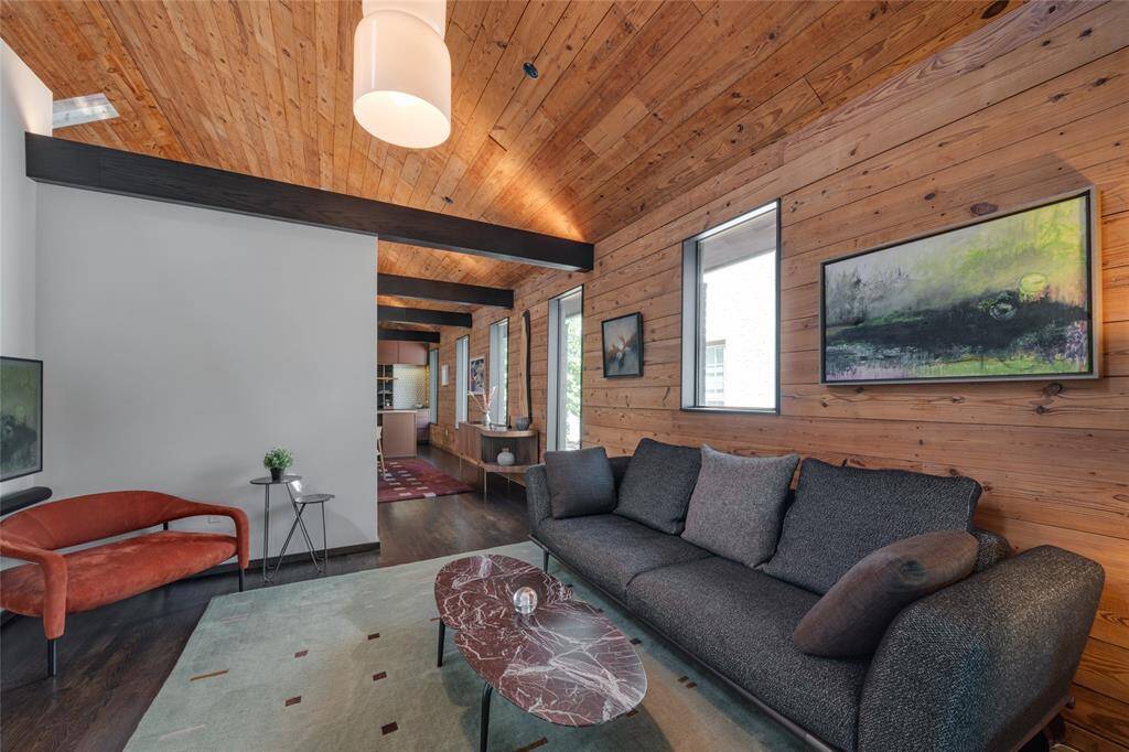 A view from the living room peaking into the dining room and kitchen. The ceiling is lined with the original shiplap of the house.