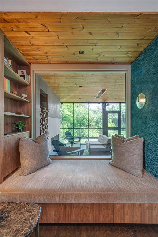 This inviting nook  is welcoming for you to cuddle up with a book. It has a view to the porch and the beautiful landscaping.