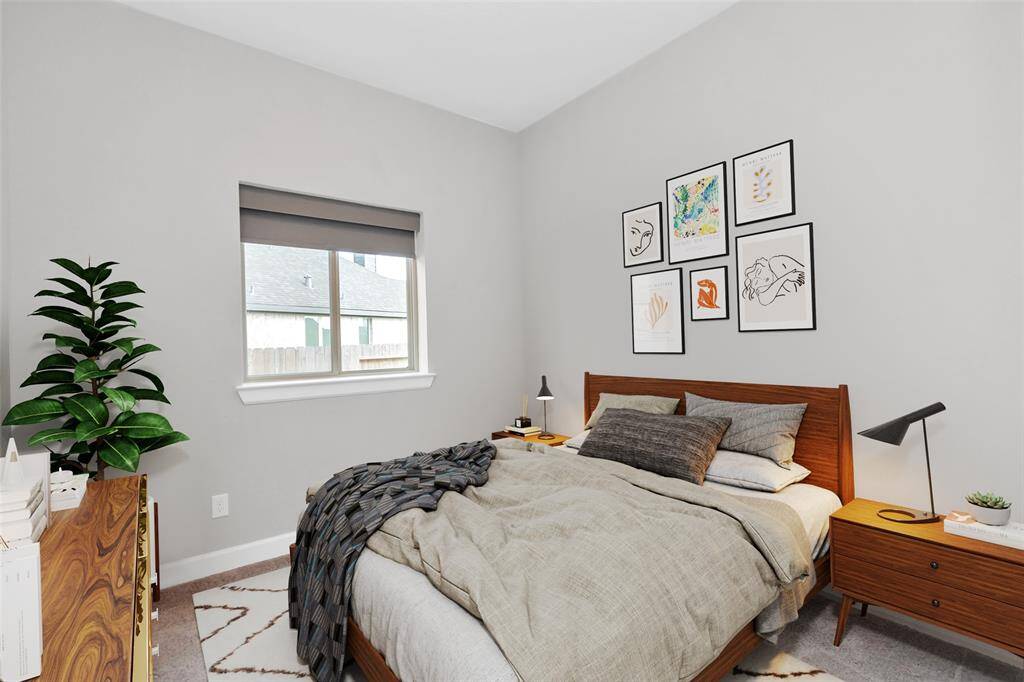 The secondary bedroom offers a warm and inviting atmosphere, featuring a large window that fills the space with natural light, neutral paint for a timeless appeal, a spacious closet for ample storage, and plush carpeting for ultimate comfort - virtually staged.