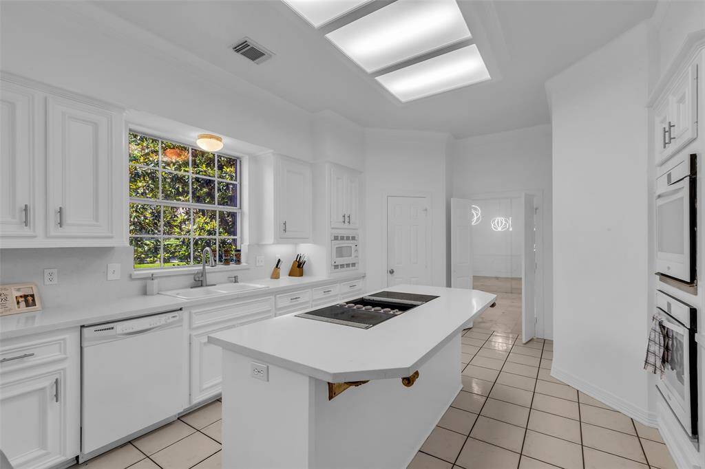 Large window over the sink where you can enjoy the lush landscaping while taking care of dinner clean up.  Handsfree pull down faucet also!