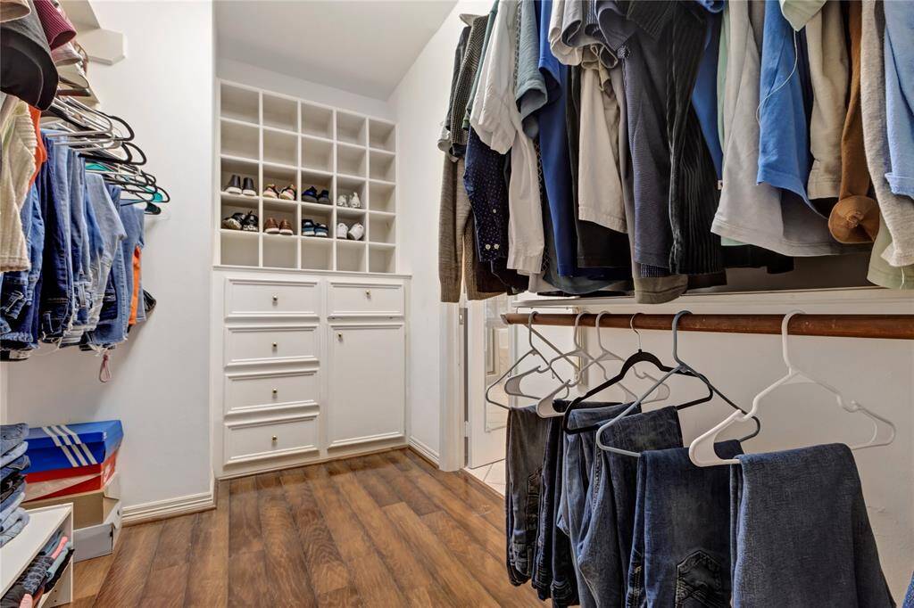 This photo shows a spacious walk-in closet featuring ample hanging space, built-in drawers, and shelving for shoes, open another door to a cedar closet! The closets have a well-organized layout, ideal for maximizing storage.