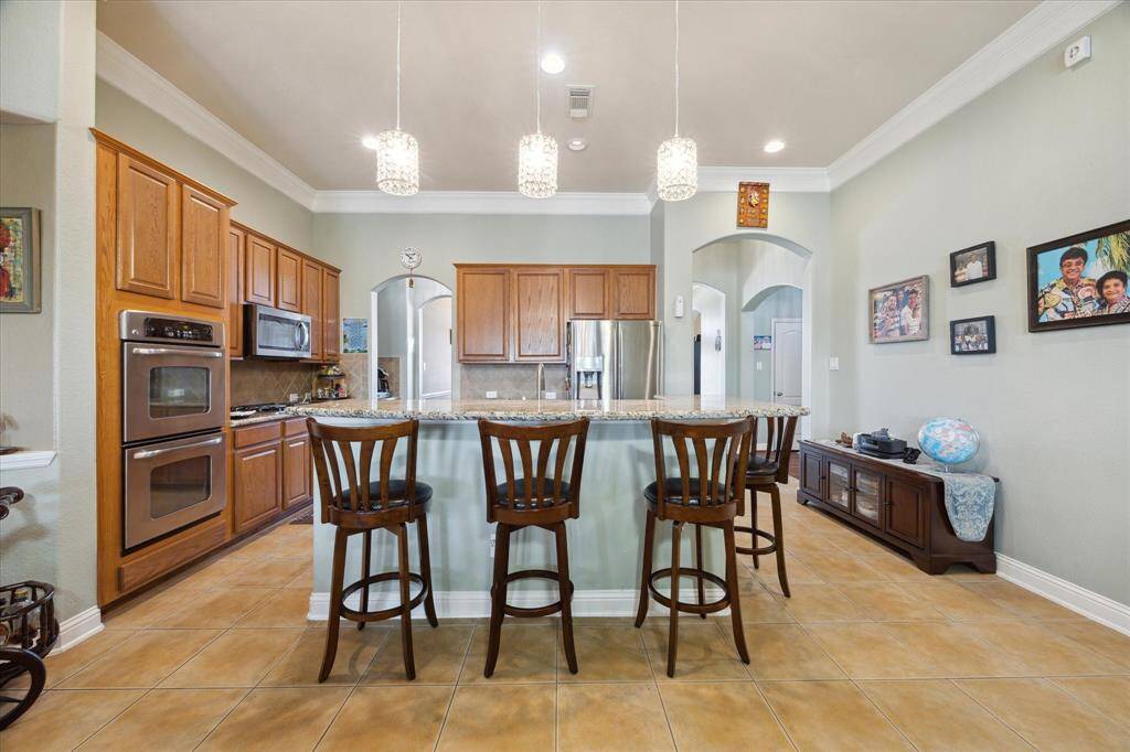 Kitchen with 2 ovens, microwave, gas cooktop and breakfast bar.  Custom Crystal  and recessive lights