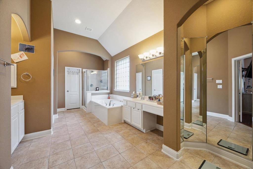 Hollywood primary bath with Jacuzzi, separate glass shower, his and her sink and closets, dressing station