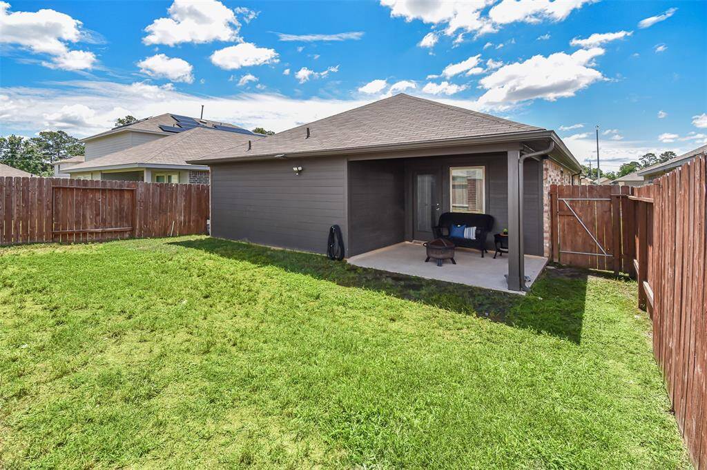 This cozy backyard with a covered patio area, perfect for outdoor relaxation. The yard is fenced, providing privacy and a safe space for activities. The lawn is well-maintained, offering a pleasant view and potential for gardening or outdoor play.