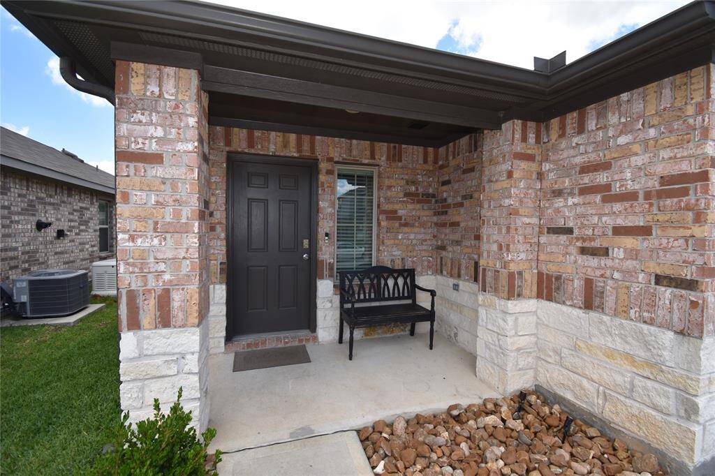 This welcoming front porch with a mix of brick and stone exterior.