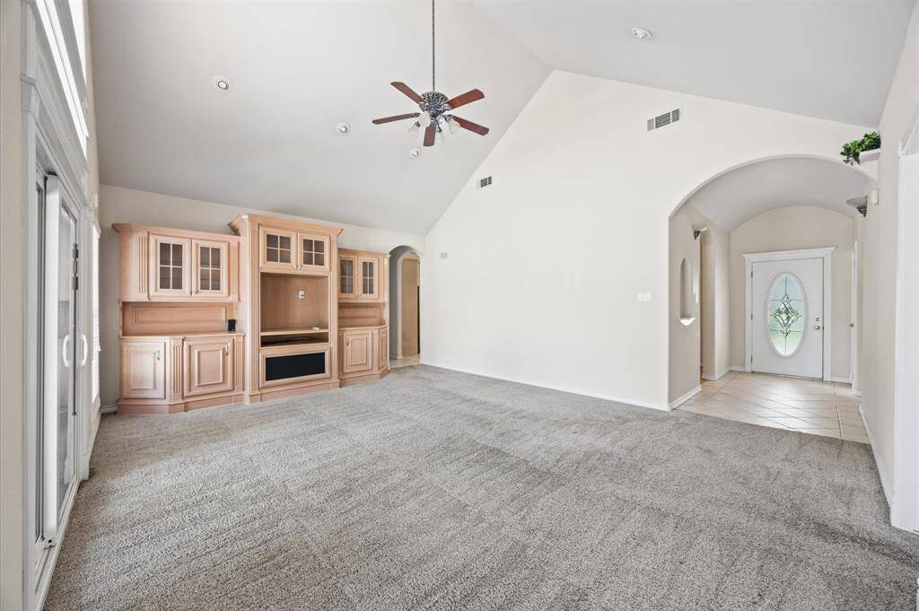 Living room with cathedral ceilings, built-ins, and recessed lighting