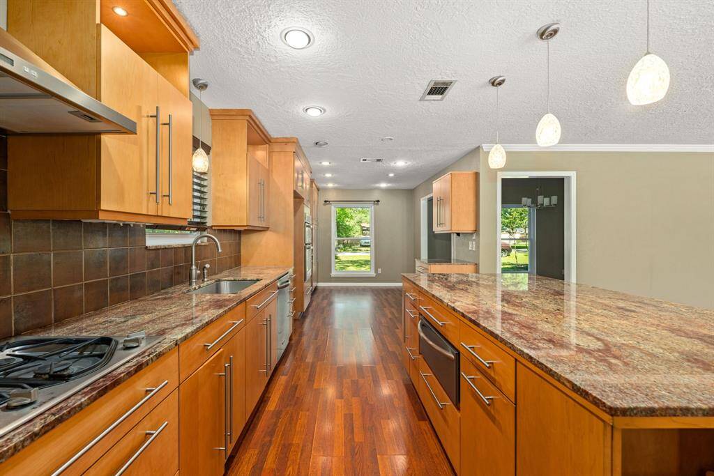 Modern and sleek spacious kitchen with stainless steel appliances, a warmer, and a view of the outdoors creating a bright and inviting atmosphere.