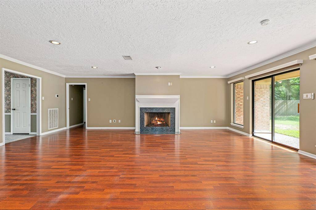 Spacious living room with large sliding glass doors and a fireplace centrally located.