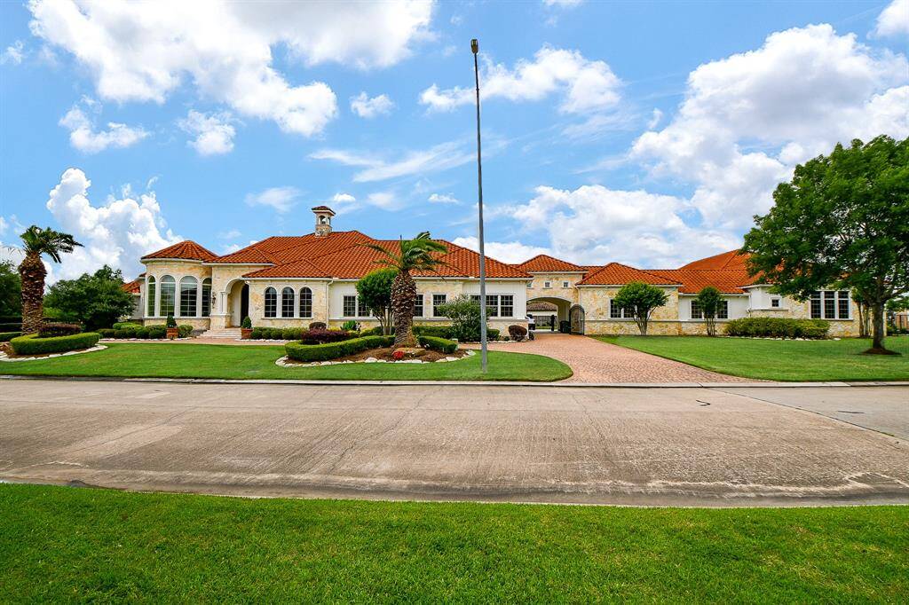 Front view of a very large home situated on 2 lots, tiled roof, sports complex, casita and great indoor and outdoor sitting areas.