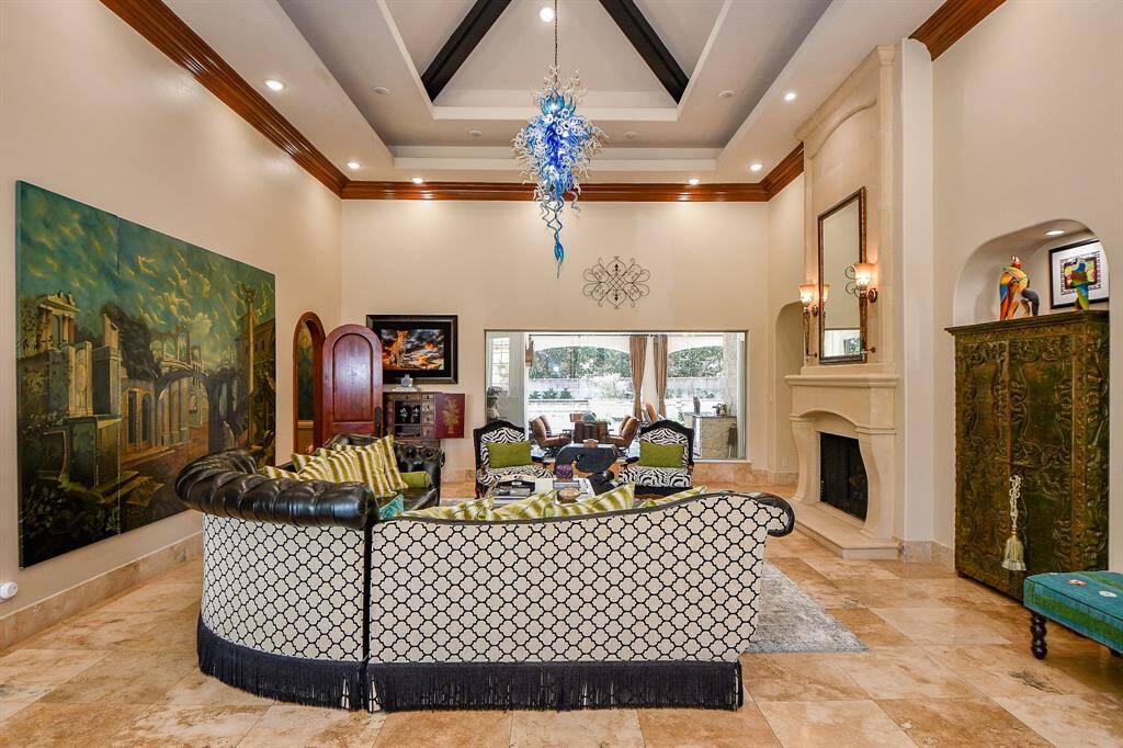 Formal living room over looking the pool with waterfalls and outdoor sitting area.