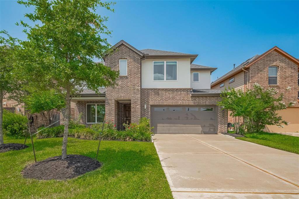 The exterior features a combination of brick and siding, with landscaped greenery and a welcoming entrance.