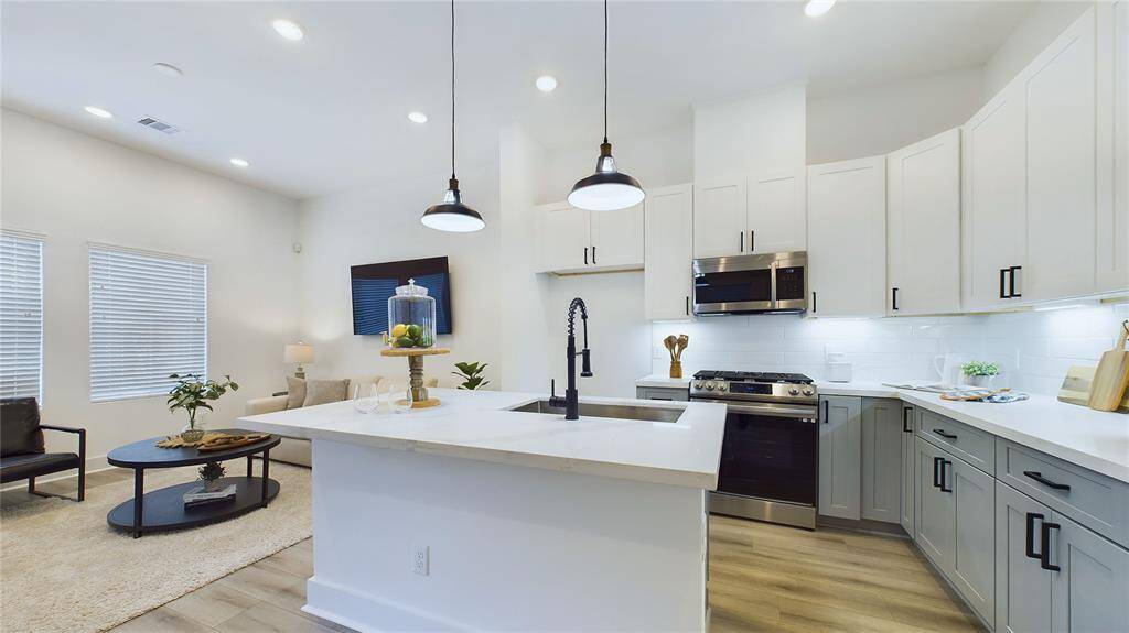 This spacious kitchen boasts an elegant quartz island with a stainless-steel sink.