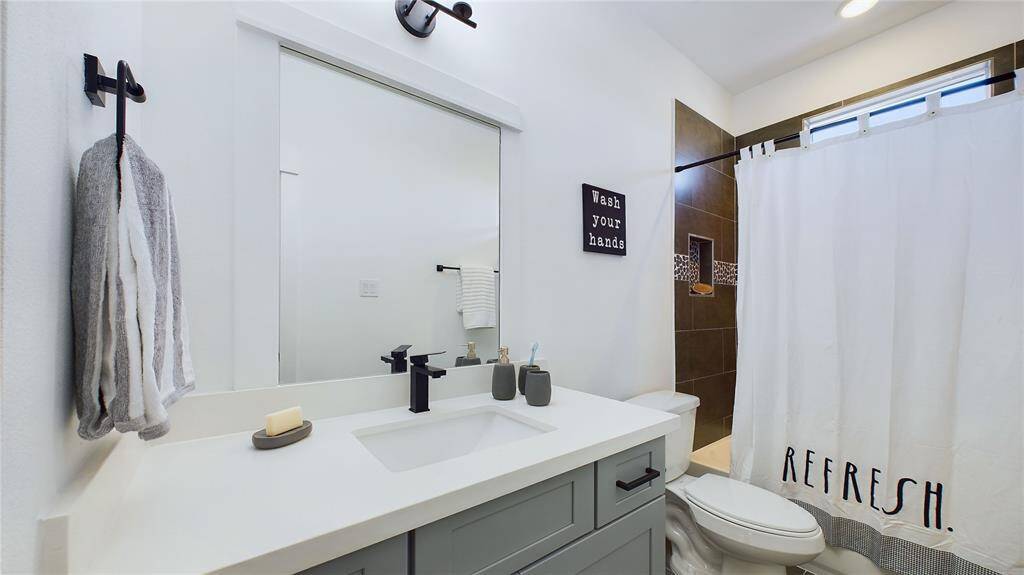 Jack and Jill secondary bathroom featuring quartz countertops and a tub/shower combination.